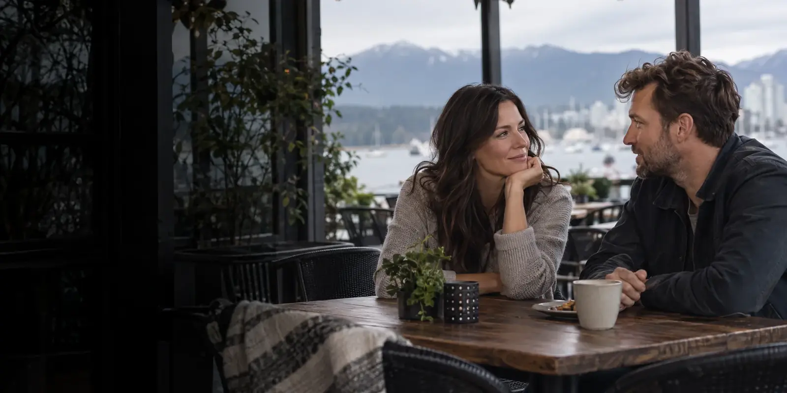 Two adults enjoying a conversation at a Vancouver waterfront cafe